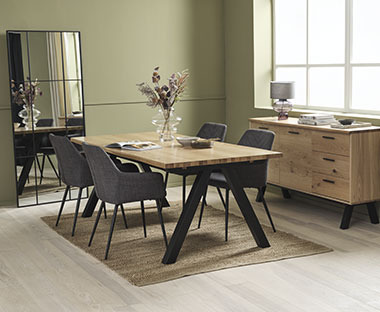 Langer Esstisch mit Holzplatte, vier dunkelgrauen Stühlen und massiver Kommode
