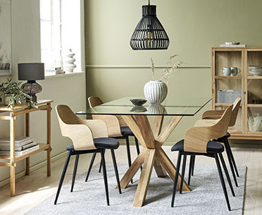 Grosser Esstisch mit Glasplatte und Holzbeinen mit schwarz-beigen Esszimmerstühlen