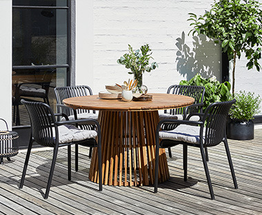 Runder Gartentisch mit rundem Fuss aus massivem Akazienholz und vier schwarze Gartentische