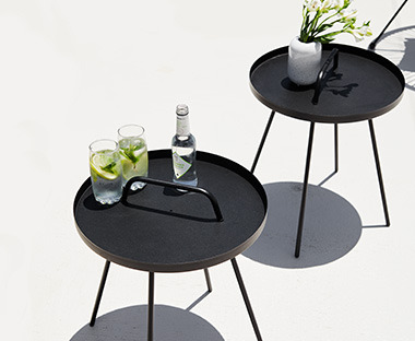 Zwei schwarze Loungetische im minimalistischen Stil mit kleinen Pflanzen darauf