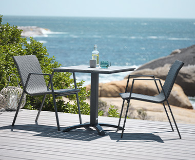 Table ronde d'extérieur en bois et métal noir et chaises combinées en osier et métal noir