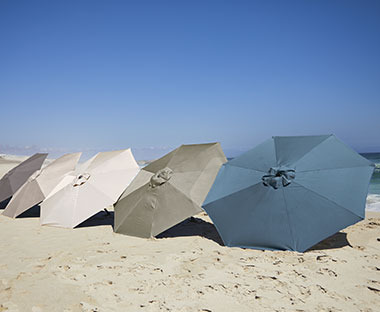 Parasols de différentes couleurs posés sur le sable en bord de mer