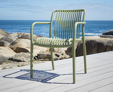 Chaise de jardin avec dossier en plastique vert au bord de la mer 
