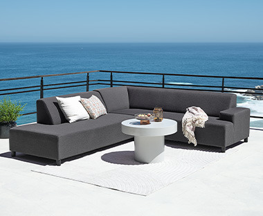 Set lounge grigio con sei posti, tappeto impermeabile, cuscini e tavolino
