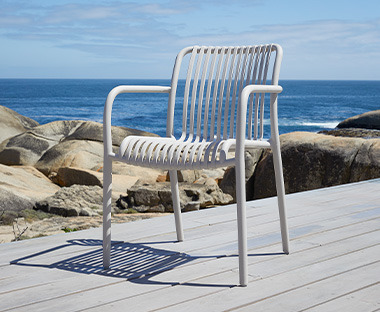 Sedia da giardino moderna in metallo di colore baige di fronte la spiaggia 