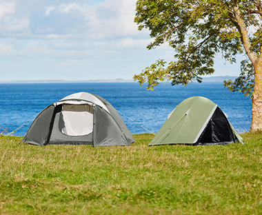 Due tende da campeggio per diverse persone posizionate di fronte il lago