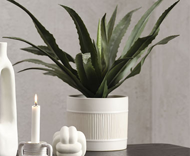 Vaso per piante bianco con bella pianta artificiale verde