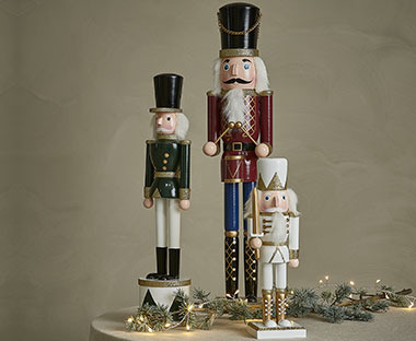 Tre soldatini natalizi in legno. Le statuette sono in diversi colori e affiancate 