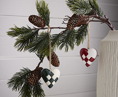 Branches de pin avec deux cœurs à carreaux pour décorer le sapin de Noël