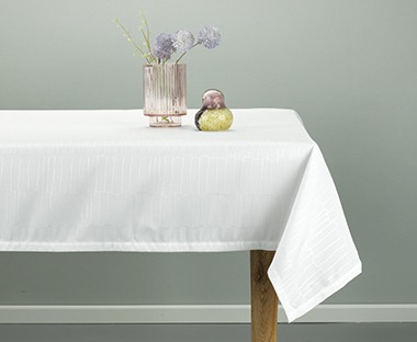 Weiße Tischdecke auf einem eckigen Tisch