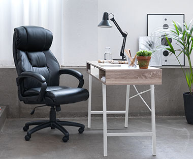 3.	Bureau de style minimaliste avec une chaise noire, un bureau en bois et des pieds blancs, le tout entouré d'objets décoratifs.
