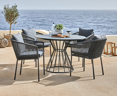 Table ronde avec piédestal géométrique et chaises modernes en noir