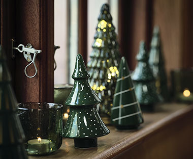 Diversi alberi di Natale decorativi posti sul davanzale di una finestrafenêtre