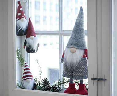 Quattro elfi natalizi posti sul davanzale di una finestra