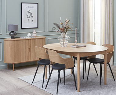 Salle à manger moderne composée d'une table en bois entourée de quatre chaises et d'un buffet chic en bois