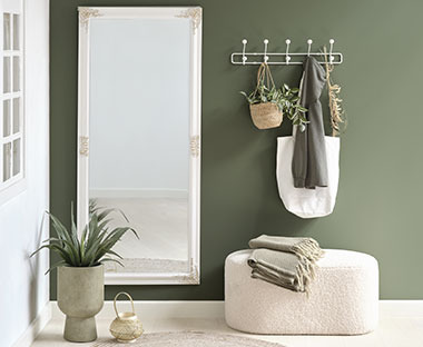 Corridoio verde con specchio lungo, appendiabiti, pouf e vaso bianco in stile moderno 