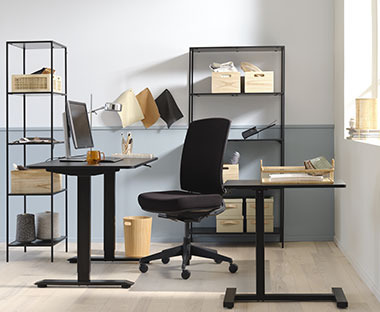 Ufficio in tinte chiare con mobili da ufficio neri e contenitori organizzativi