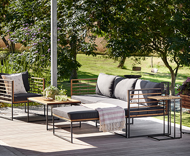 Set lounge in legno e metallo con cuscini grigi con sei posti con tappeto impermeabile e cuscini beige in schiuma e tavolino