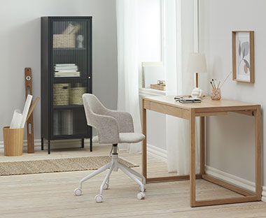  Bureau avec bureau en bois et chaise de bureau, sur le côté se trouve une armoire noire avec un panier en bois.