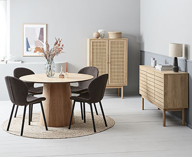 Salon moderne avec table de salle à manger ronde, quatre chaises, une petite armoire et un buffet en bois