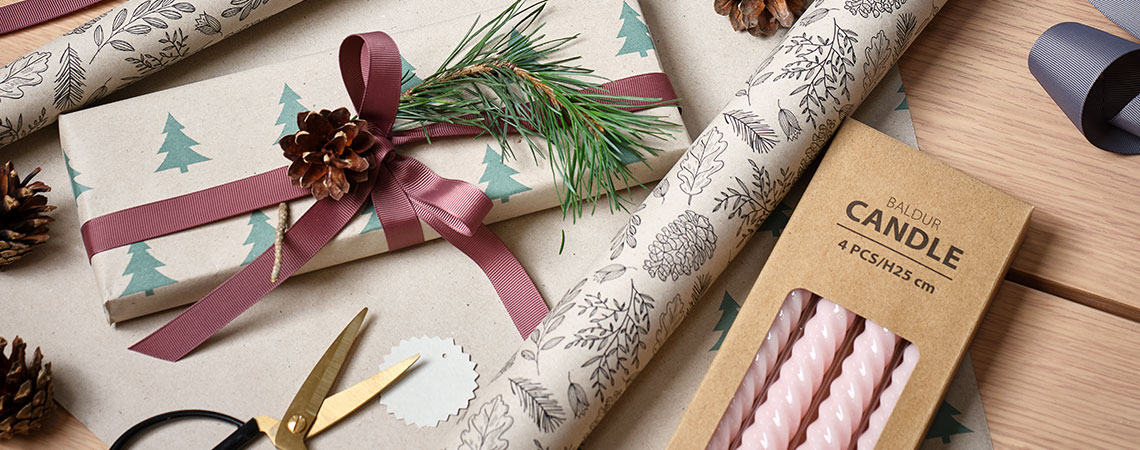 Ein Tisch mit Geschenkpapier, Weihnachtsdeko und Geschenken