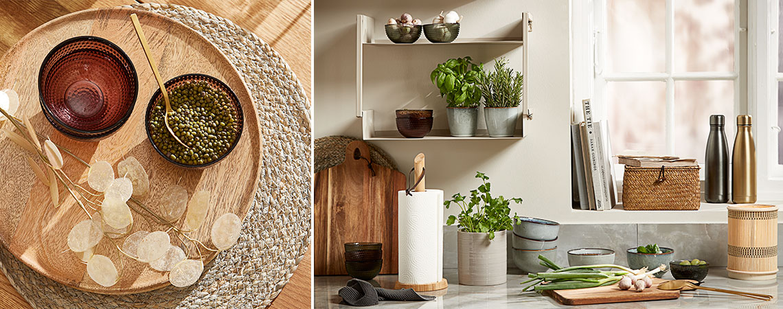 Bols en verre dans un set de table en bois, mugs en grès avec des herbes fraiches aromatiques sur une étagère murale dans une cuisine