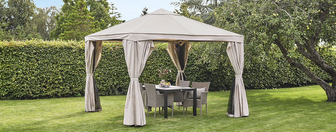 Tonnelle beige dans un jardin avec du mobilier lounge