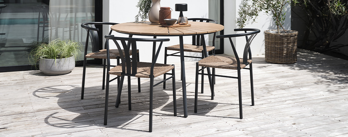 Table de jardin en noir et bois et 4 chaises de jardin sur un patio