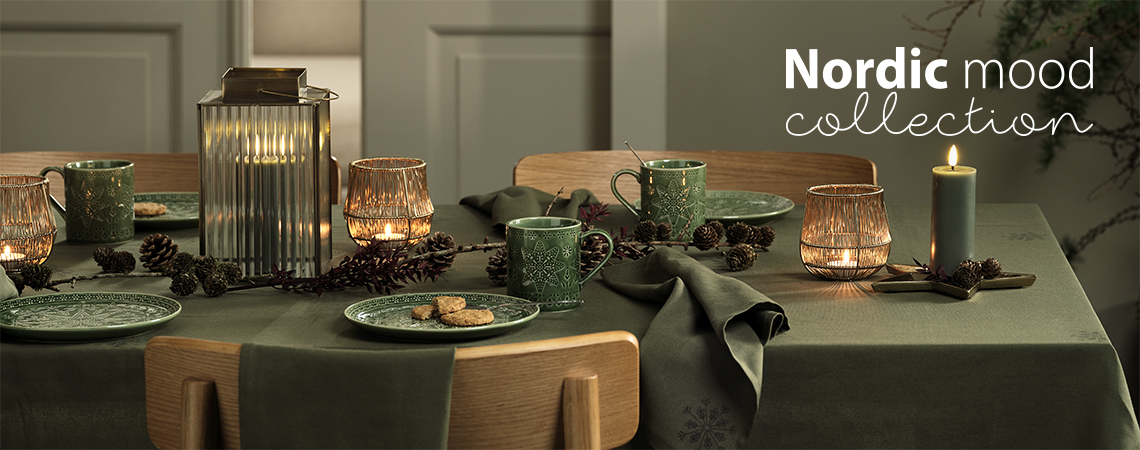 Table de Noël avec des assiettes vertes, des mugs verts, une lanterne, des bougies 