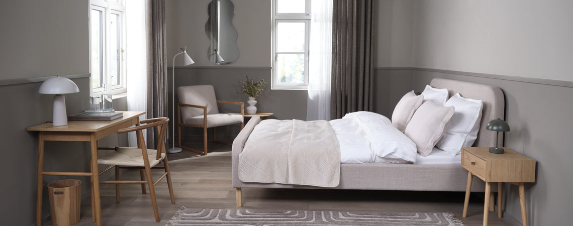 Cadre de lit KONGSBERG avec la table de nuit HOKKSUD Un cadre de lit dans une chambre avec un espace bureau