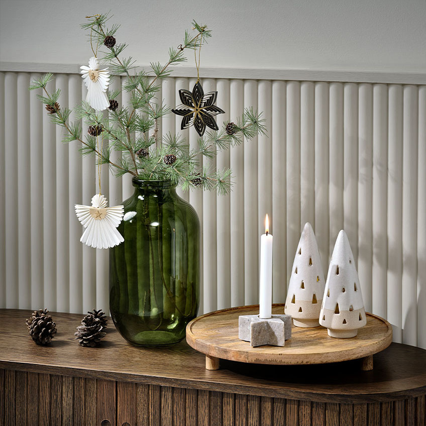 Rametto di abete con decorazioni in un vaso con decorazioni natalizie scandinave