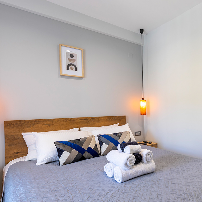 Bettgestell VEDDE, Satin-Bettbezug NELL und Handtücher UPPSALA Möbliertes Schlafzimmer mit Bett, Bettzeug und Handtüchern