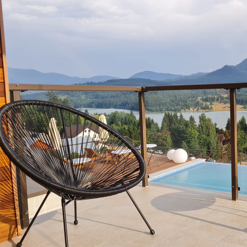 Espace piscine meublé avec des chaises et des montagnes en arrière-plan