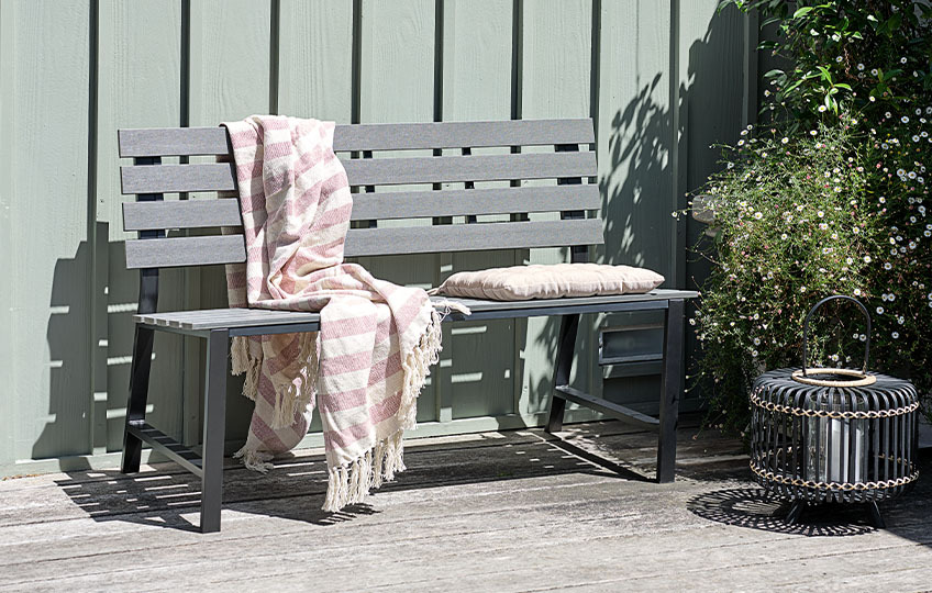 Banc de jardin en imitation bois avec un couverture et un coussin de chaise