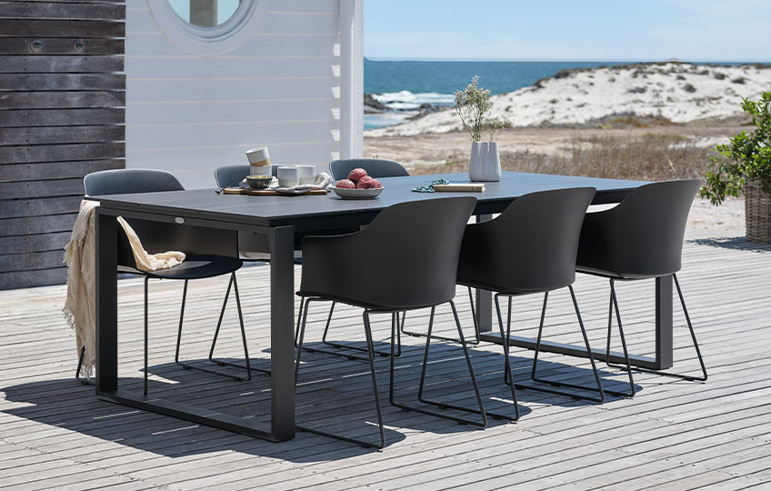 Gartentisch mit Platte aus Verbundholz und Gartenstühlen aus Kunststoff