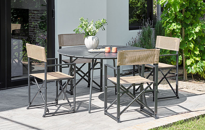 Gartentisch mit Tischplatte aus Faserzement und Gartenstühlen im Garten