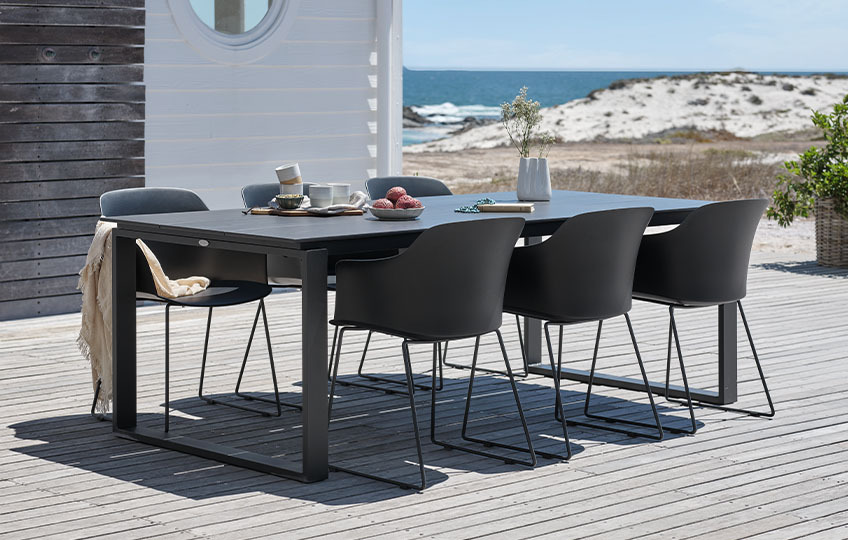Grosser Gartentisch und Stühle auf der Veranda am Strand