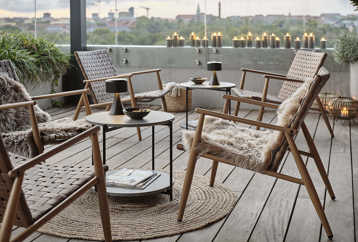Garten-Lounge-Sessel und Tische auf gemütlichem Balkon