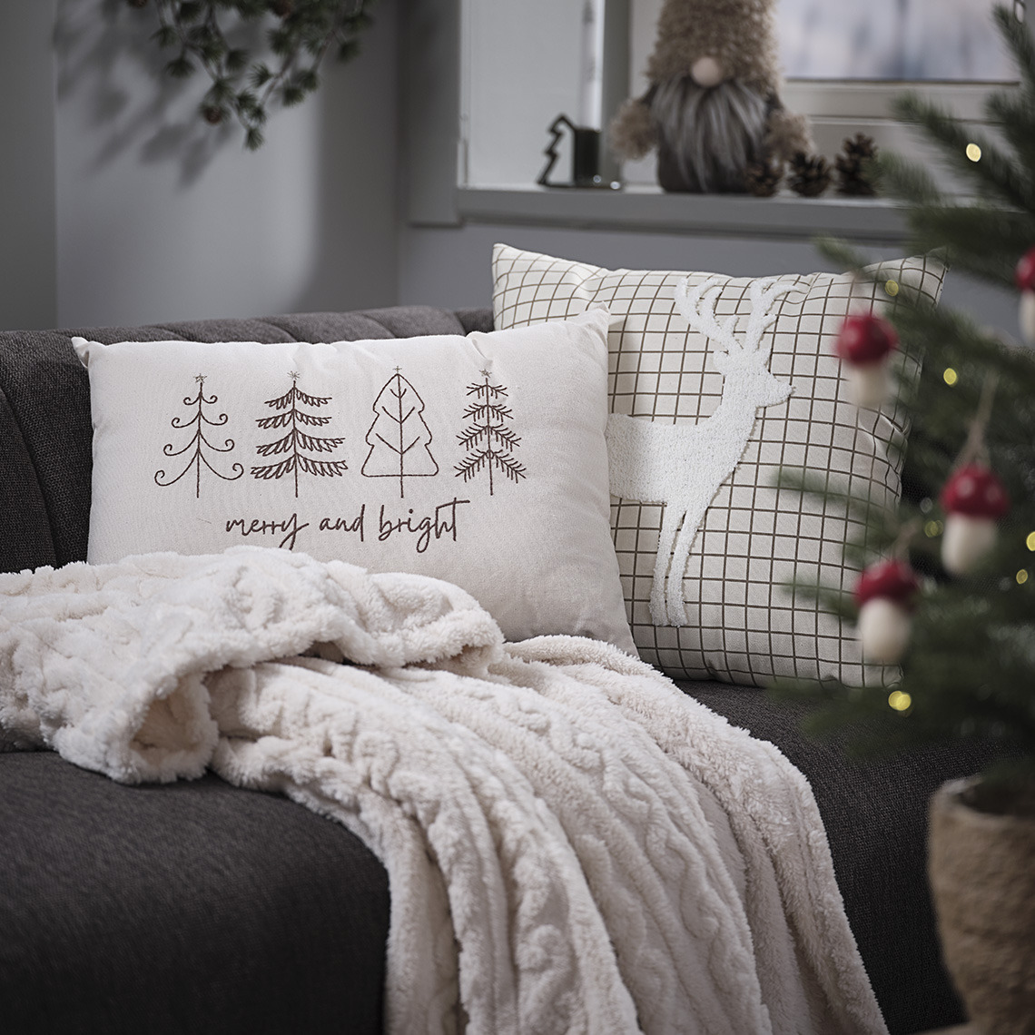 Sofa mit weihnachtlichen Zierkissen und einer Kuscheldecke