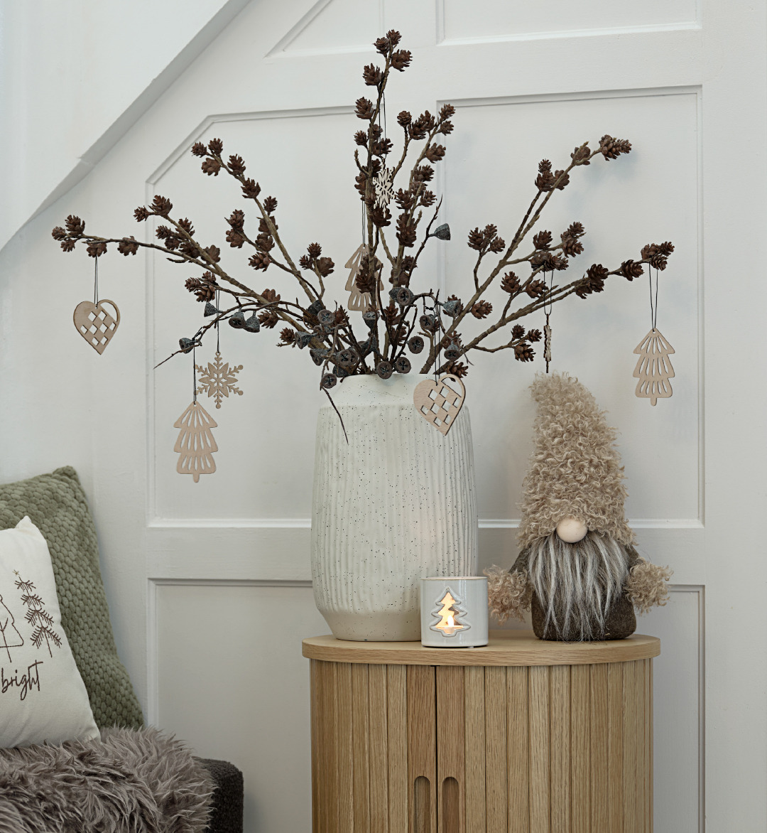 Décorations d'arbre de Noël BESTLA, vase CHRISTIAN et lutin de Noël LARVIKIT Une petite table avec un vase de décorations de Noël et un lutin de Noël à côté