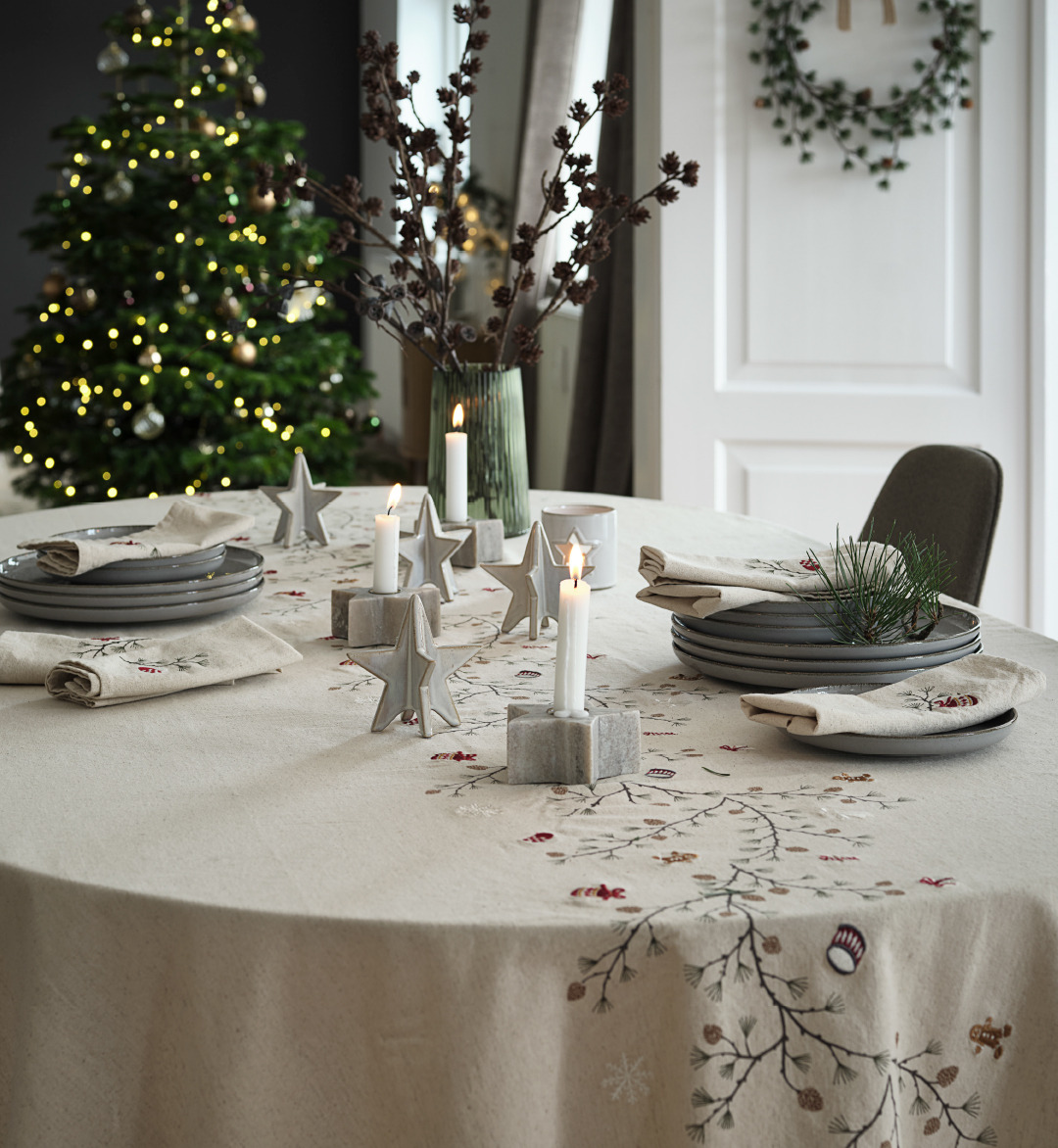 Une table dressée pour Noël avec une nappe brodée NELLIKE aux motifs de Noël Table de Noël joliment décorée avec une nappe de Noël brodée