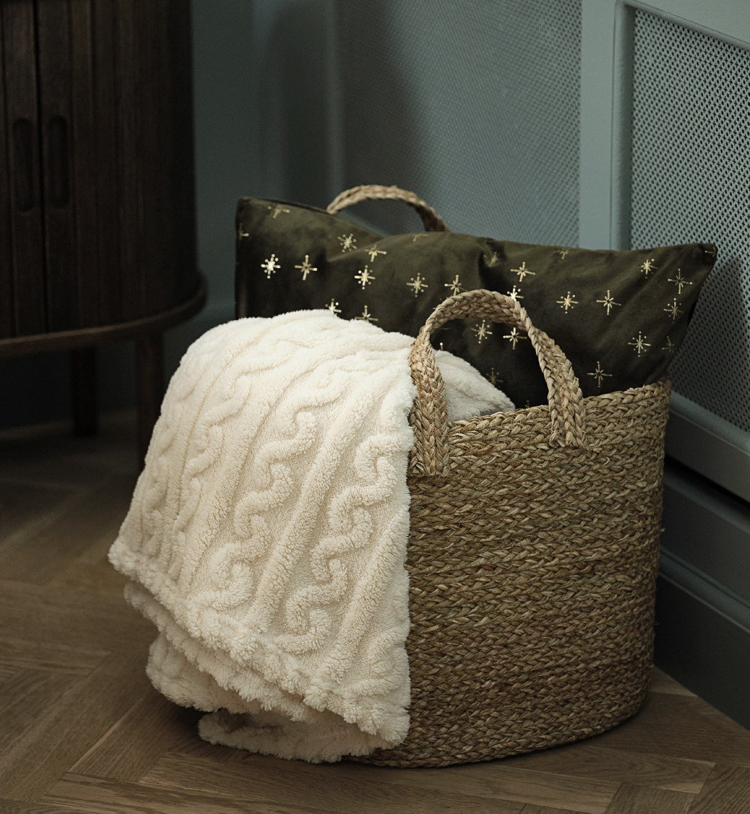Panier ELI avec couverture SELENIT et coussin décoratif ALVALDE Un panier avec une couverture douce et un coussin décoratif vert avec des étoiles dorées