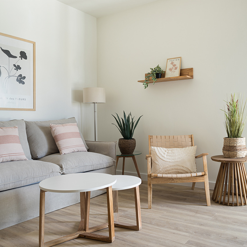 Wohnbereich mit Sofa, Sessel, Couchtischen und Dekoration