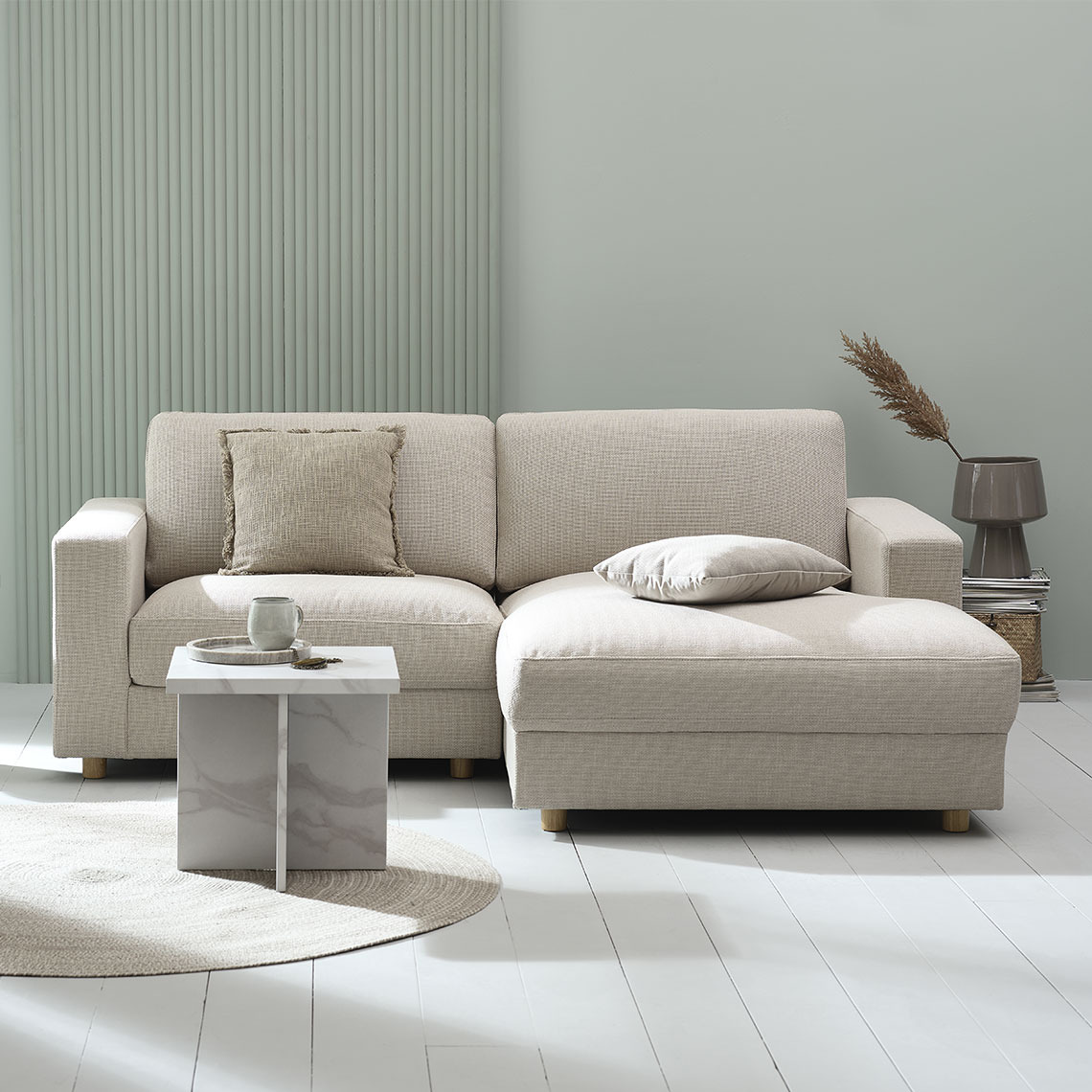 Beigefarbenes 2-Sitzer-Sofa mit Chaiselounge in einem modernen und minimalistischen Wohnbereich