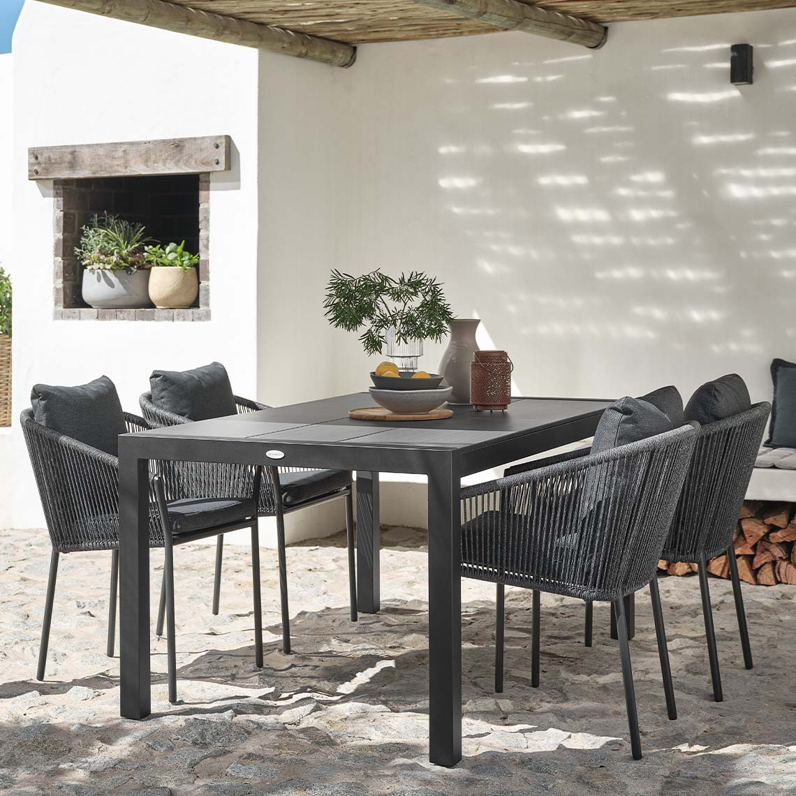 Table de jardin et quatre chaises de jardin avec coussins à séchage rapide sur la terrasse