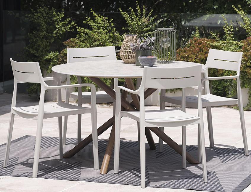 Table de jardin SANDVIG et chaises de jardin INGSTRUP Table ronde et chaises de jardin sur un patio dans un jardin