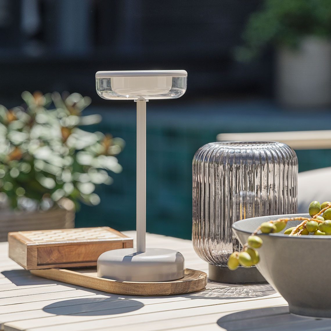  Eine Tischleuchte für den Aussenbereich schmückt einen Loungetisch.