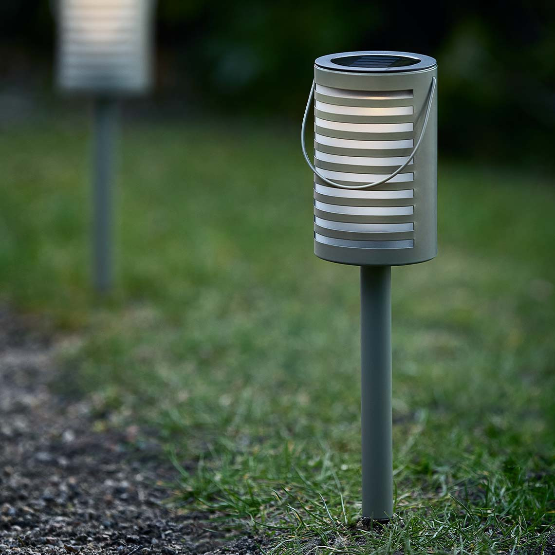 Die Solarlampe im modernen skandinavischen Design wurde in den Rasen gesteckt