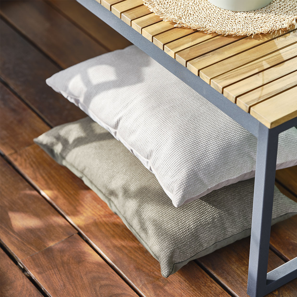 Cuscino LILJE Cuscini beige sistemati sotto una panca da giardino, pronti a offrire comfort extra durante i momenti di relax all’aperto