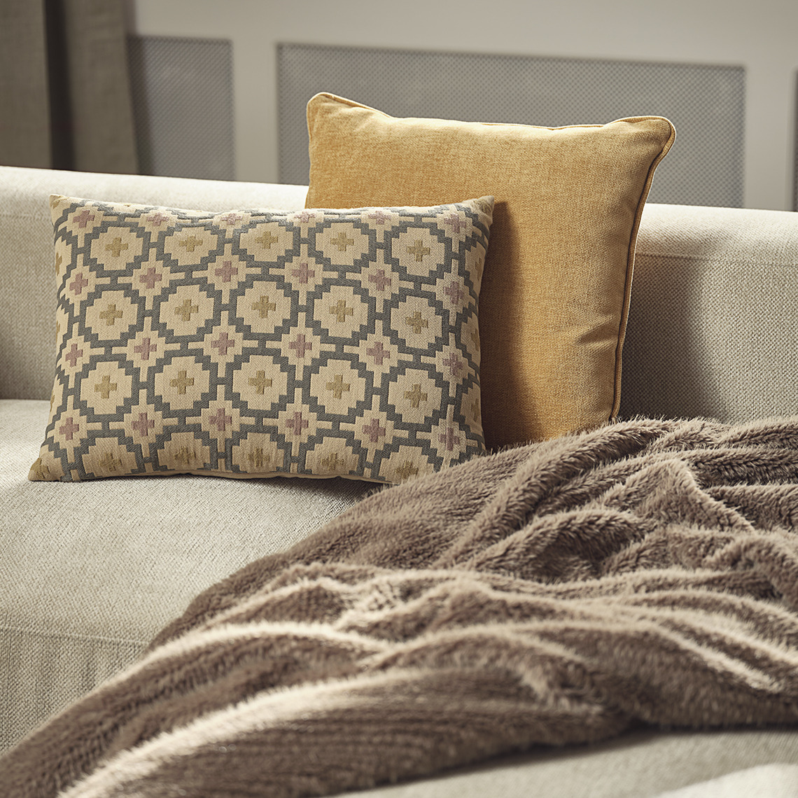 Gelbes HORNFIOL und gemustertes BANKSIA Kissen, VINTEREIK Decke aus Kunstfell Sofa mit gelbem und gemustertem Kissen sowie einer Decke